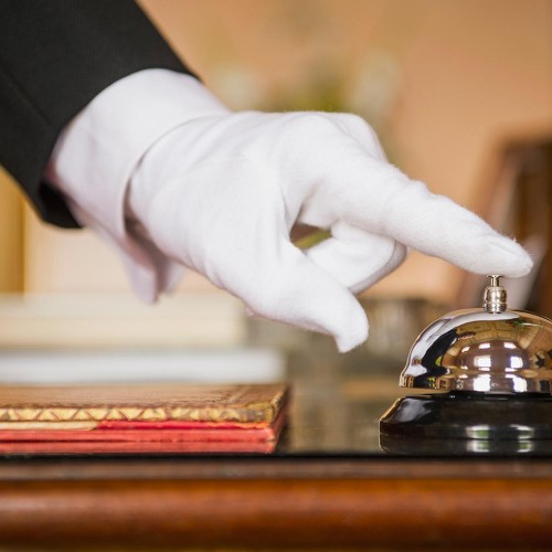 Close up of Caucasian butler ringing bell