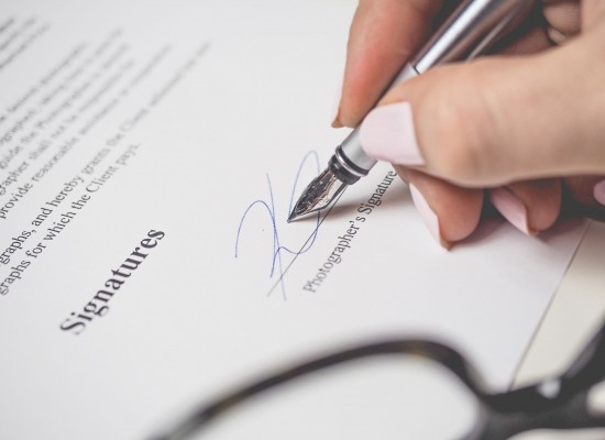 person-holding-silver-pen-signing-photographers-signature-175045