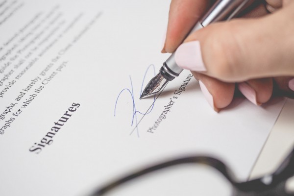 person-holding-silver-pen-signing-photographers-signature-175045